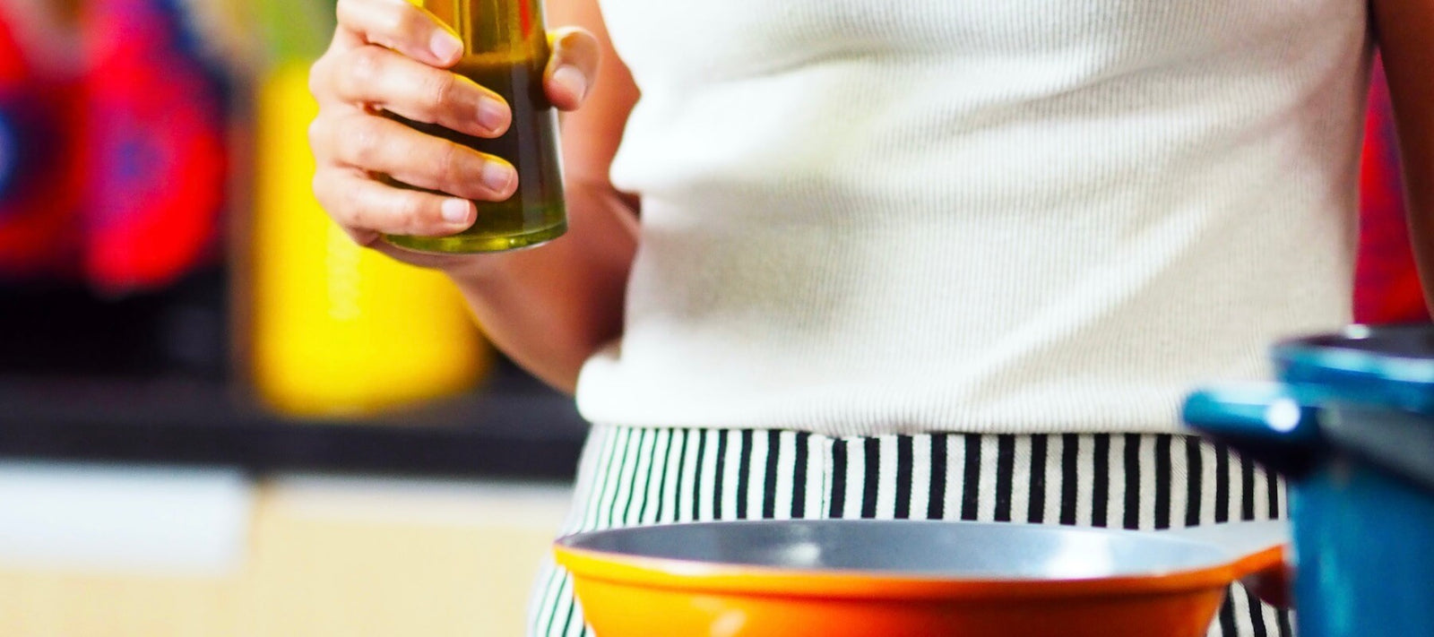 Eine Flasche Olivenöl vor einem flachen Bauch